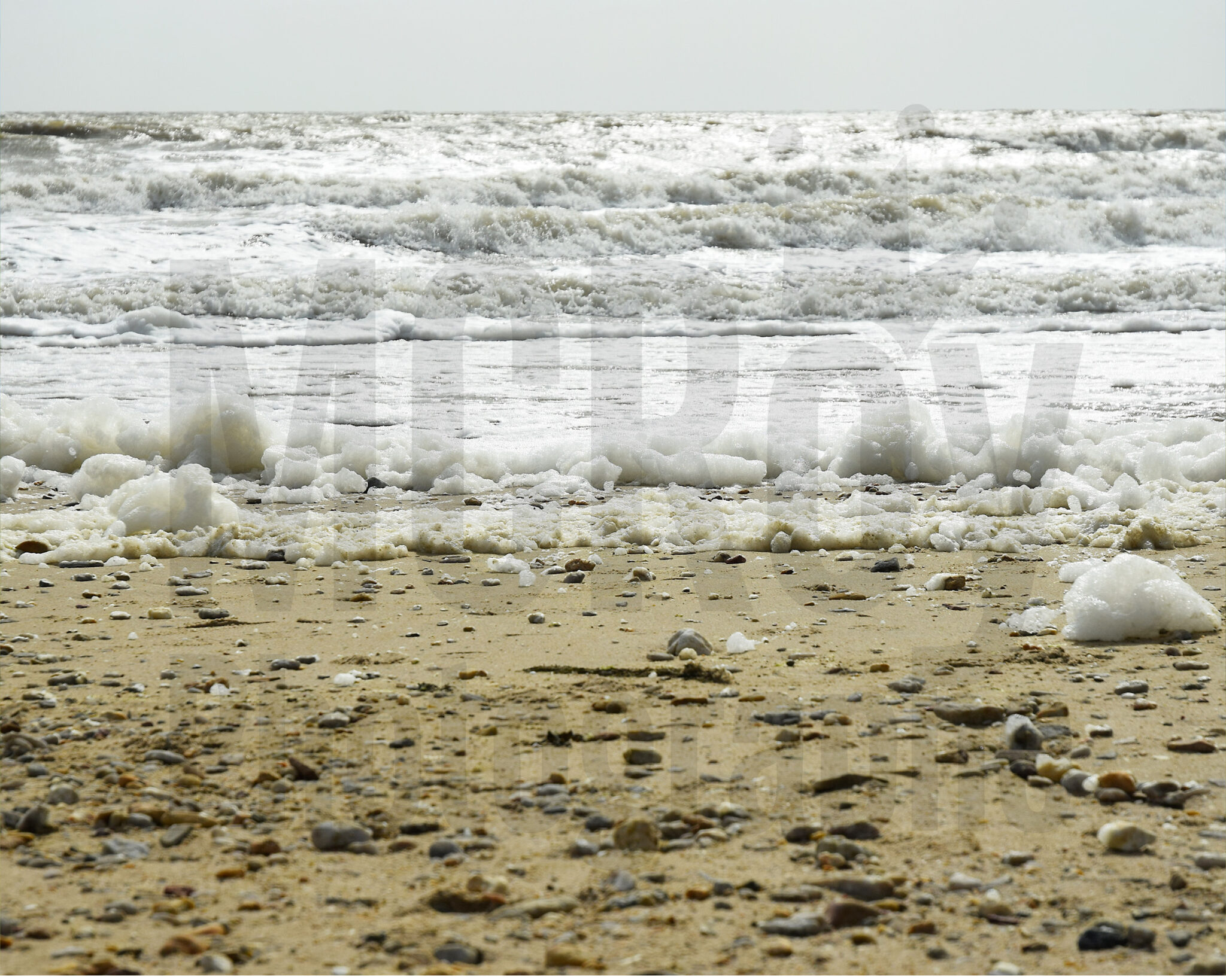 La mer, l'écume, le sable et galets