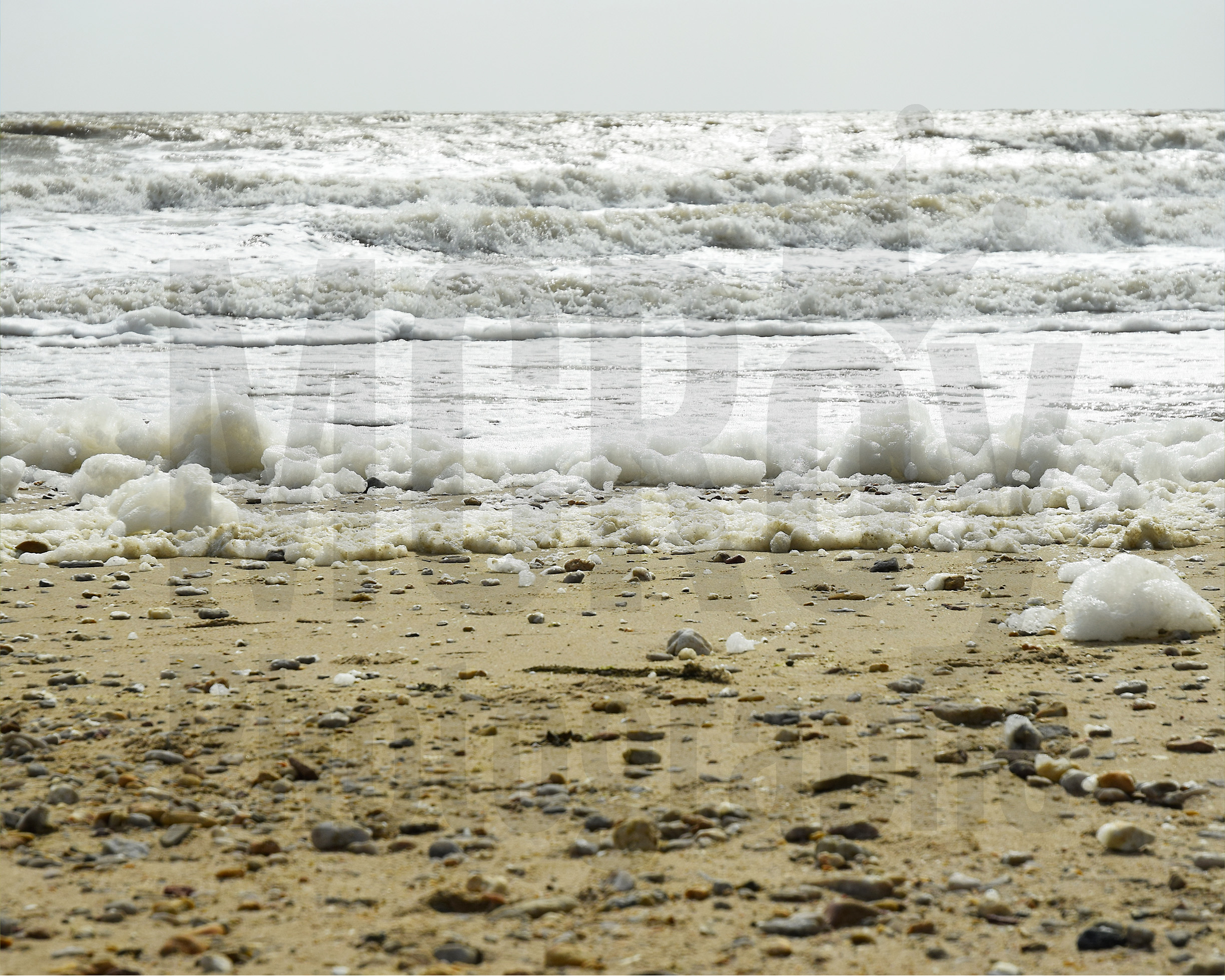 La mer, l'écume, le sable et galets